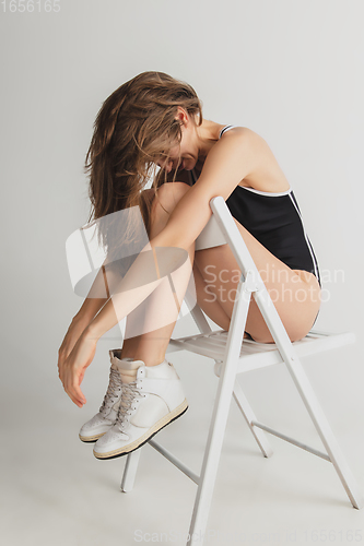 Image of Beautiful young woman\'s portrait isolated on grey studio background. Having fun, happy, full length