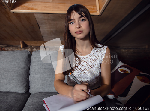 Image of Young woman talking, working during videoconference with colleagues at home office