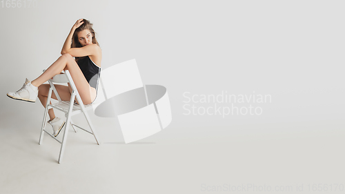 Image of Beautiful young woman\'s portrait isolated on grey studio background. Having fun, happy, full length