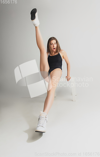Image of Beautiful young woman\'s portrait isolated on grey studio background. Having fun, happy, full length
