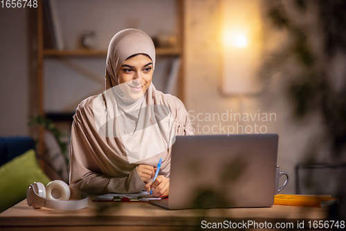 Image of Happy muslim woman at home during online lesson. Modern technologies, remote education, ethnicity concept