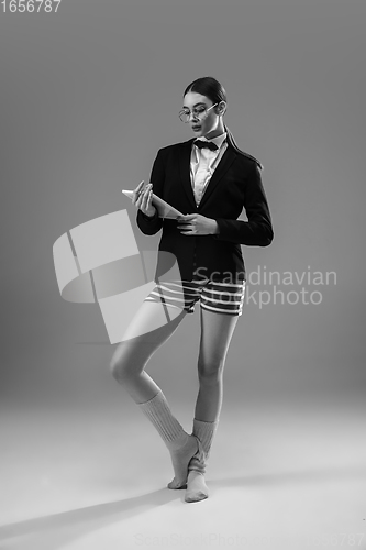 Image of Young fashionable, stylish woman wearing jacket and socks working from home. Fashion during insulation \'cause of coronavirus pandemic