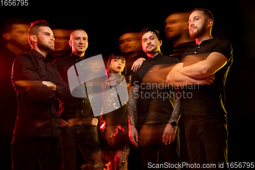 Image of Musician\'s band isolated on dark studio background in neon light