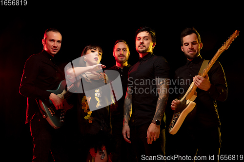 Image of Musician\'s band isolated on dark studio background in neon light