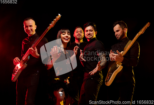 Image of Musician\'s band isolated on dark studio background in neon light