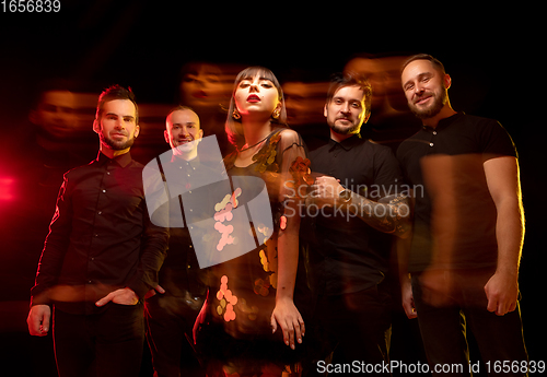 Image of Musician\'s band isolated on dark studio background in neon light