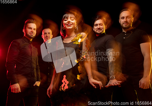 Image of Musician\'s band isolated on dark studio background in neon light