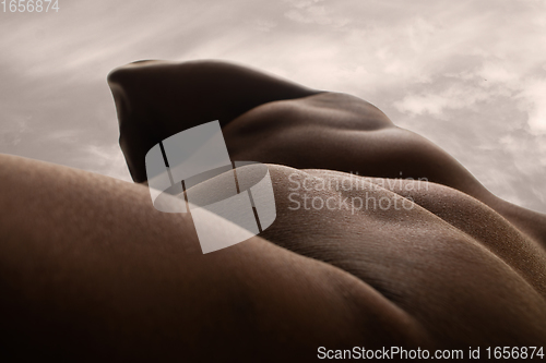 Image of Detailed texture of human skin. Close up shot of young african-american male body like landscape with the sky background