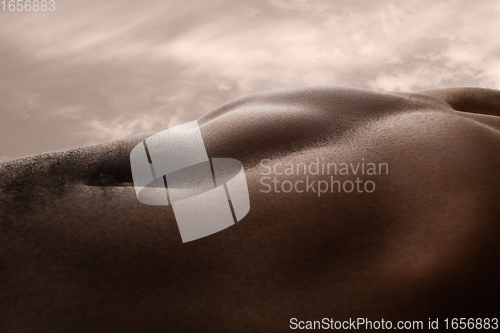 Image of Detailed texture of human skin. Close up shot of young african-american male body like landscape with the sky background