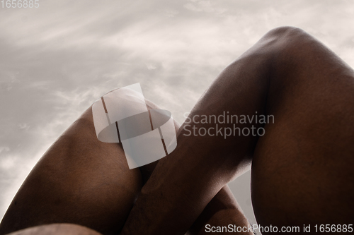 Image of Detailed texture of human skin. Close up shot of young african-american male body like landscape with the sky background