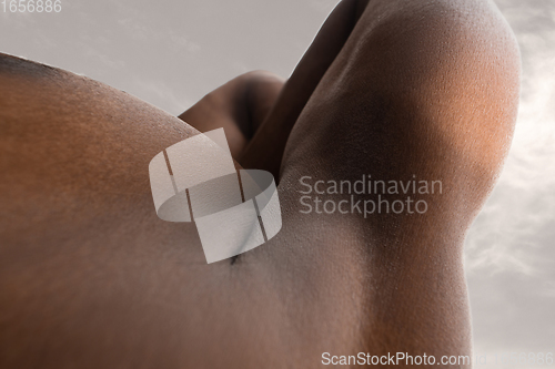 Image of Detailed texture of human skin. Close up shot of young african-american male body like landscape with the sky background