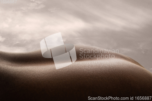 Image of Detailed texture of human skin. Close up shot of young african-american male body like landscape with the sky background