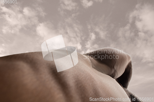 Image of Detailed texture of human skin. Close up shot of young african-american male body like landscape with the sky background