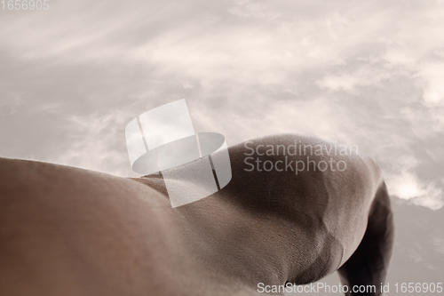 Image of Detailed texture of human skin. Close up shot of young african-american male body like landscape with the sky background