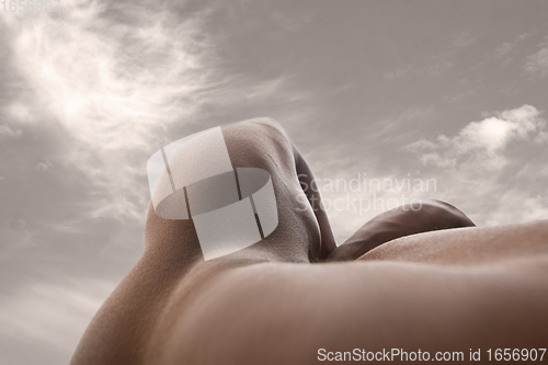 Image of Detailed texture of human skin. Close up shot of young african-american male body like landscape with the sky background