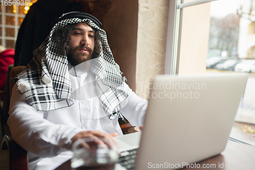 Image of Arabian businessman working in office, business centre using devicesm gadgets. Lifestyle