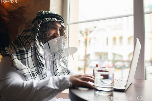 Image of Arabian businessman working in office, business centre using devicesm gadgets. Lifestyle