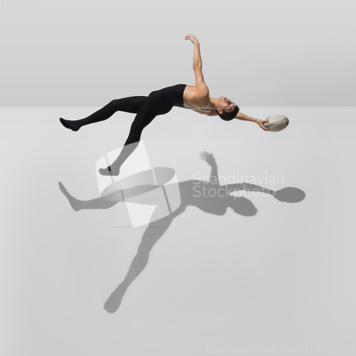 Image of Beautiful young male athlete practicing on white studio background with shadows in jump, air flying