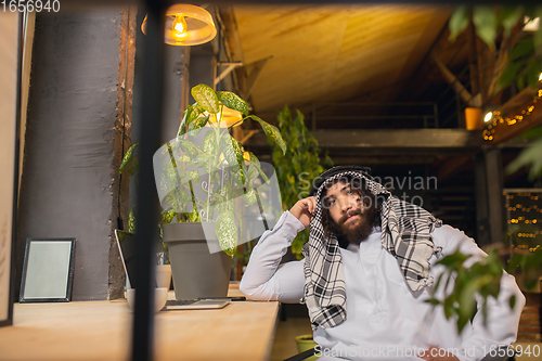 Image of Arabian businessman working in office, business centre using devicesm gadgets. Lifestyle