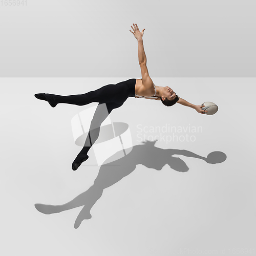 Image of Beautiful young male athlete practicing on white studio background with shadows in jump, air flying