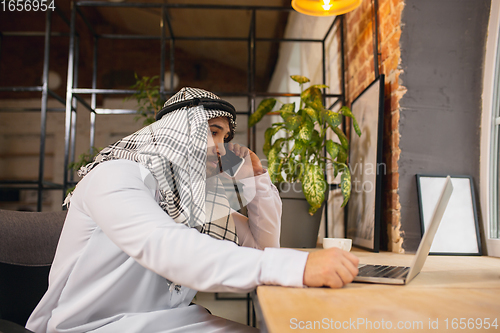 Image of Arabian businessman working in office, business centre using devicesm gadgets. Lifestyle