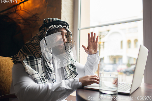 Image of Arabian businessman working in office, business centre using devicesm gadgets. Lifestyle