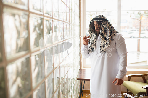 Image of Arabian businessman working in office, business centre using devicesm gadgets. Lifestyle