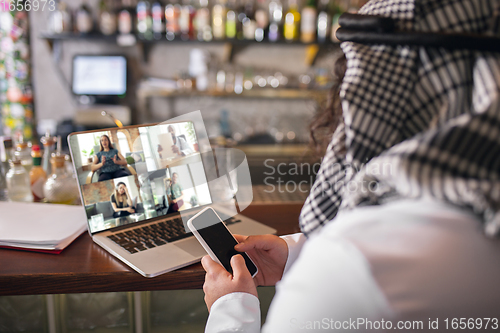 Image of Arabian businessman working in office, business centre using devicesm gadgets. Lifestyle