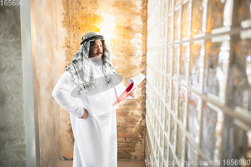 Image of Arabian businessman working in office, business centre using devicesm gadgets. Lifestyle