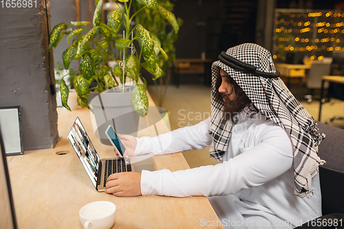 Image of Arabian businessman working in office, business centre using devicesm gadgets. Lifestyle