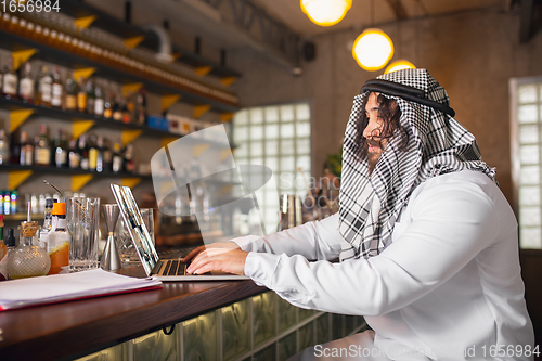 Image of Arabian businessman working in office, business centre using devicesm gadgets. Lifestyle