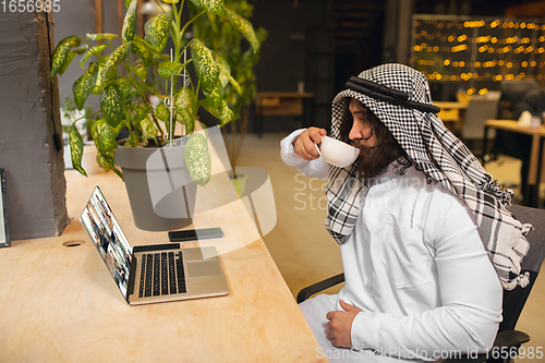 Image of Arabian businessman working in office, business centre using devicesm gadgets. Lifestyle