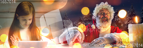 Image of Happy caucasian little girl during video call or messaging with Santa using laptop and home devices, celebration or ad flyer with copyspace