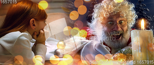 Image of Happy caucasian little girl during video call or messaging with Santa using laptop and home devices, celebration or ad flyer with copyspace