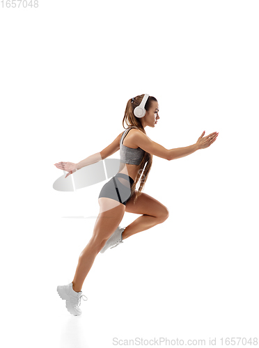 Image of Caucasian professional female runner, athlete training isolated on white studio background. Copyspace for ad.