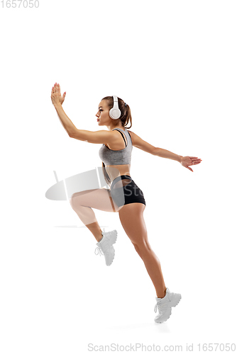 Image of Caucasian professional female runner, athlete training isolated on white studio background. Copyspace for ad.