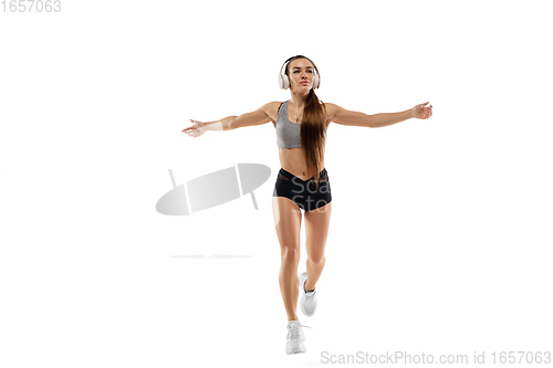 Image of Caucasian professional female runner, athlete training isolated on white studio background. Copyspace for ad.