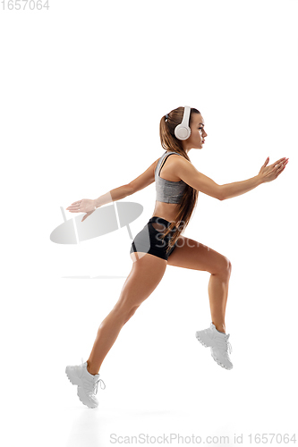 Image of Caucasian professional female runner, athlete training isolated on white studio background. Copyspace for ad.