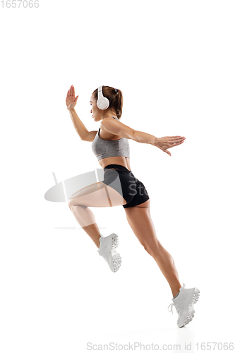 Image of Caucasian professional female runner, athlete training isolated on white studio background. Copyspace for ad.