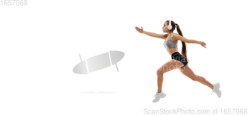 Image of Caucasian professional female runner, athlete training isolated on white studio background. Copyspace for ad.