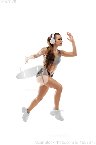 Image of Caucasian professional female runner, athlete training isolated on white studio background. Copyspace for ad.