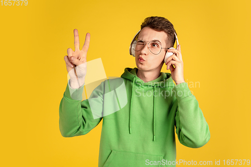 Image of Portrait of young caucasian man isolated on yellow studio background