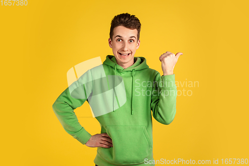 Image of Portrait of young caucasian man isolated on yellow studio background