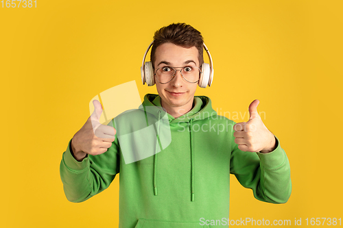 Image of Portrait of young caucasian man isolated on yellow studio background