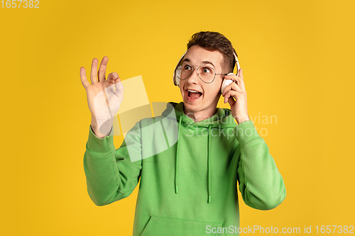 Image of Portrait of young caucasian man isolated on yellow studio background