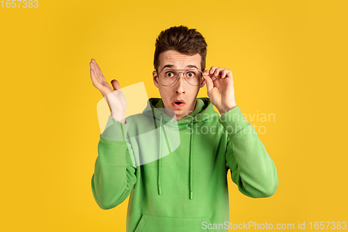 Image of Portrait of young caucasian man isolated on yellow studio background