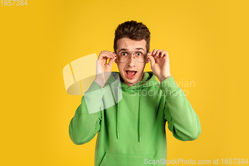 Image of Portrait of young caucasian man isolated on yellow studio background