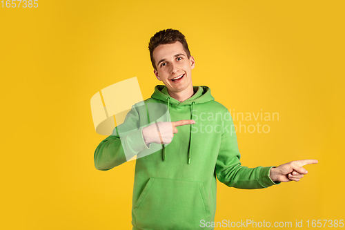 Image of Portrait of young caucasian man isolated on yellow studio background