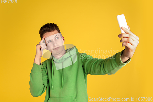 Image of Portrait of young caucasian man isolated on yellow studio background