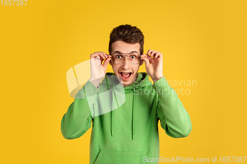 Image of Portrait of young caucasian man isolated on yellow studio background